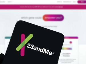 The 23andMe Holding Co logo is displayed on smartphone
