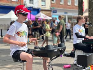 Sam, performing as part of The SCARKEEZ, playing the drums.