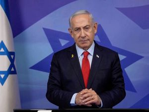 Benjamin Netanyahu standing beside an Israeli flag