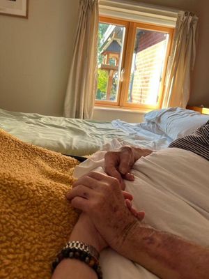 Ann holding hands with her dad at St Giles Hospice