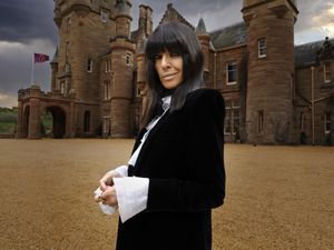 Claudia Winkleman in front of the castle where the Traitors is filmed