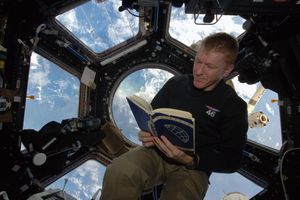 Tim Peake reading ion board the ISS. 