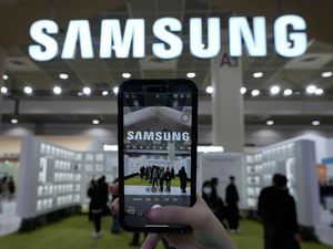 A visitor takes a photo of the Samsung logo at the Semiconductor Exhibition 2024 in Seoul, South Korea