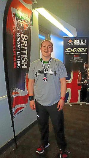 Louise Webster proudly shows off her medal.