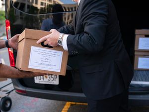 Workers loading boxes of documents into a vehicle