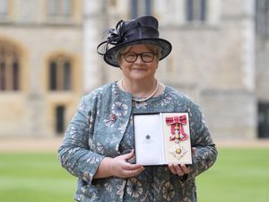Dame Therese Coffey holding up a medal