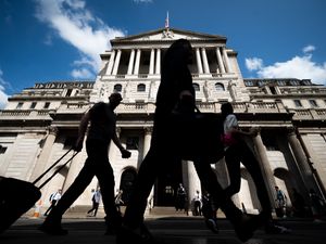 People walk past the Bank of England