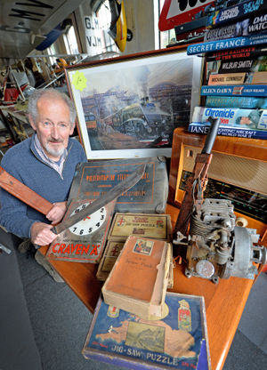Alec Brew with jigsaws, a laundry box, Colombian machetes, a Craven A clock and radio donated to the museum