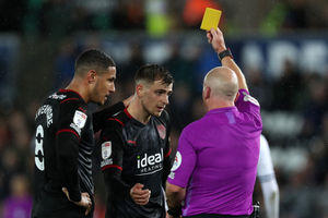 Referee Simon Hooper shows a yellow card to Jayson Molumby. (Photo by Adam Fradgley/WBA FC via Getty Images).