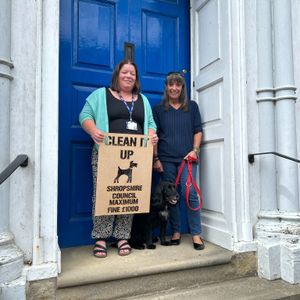 A town council member and county council's dog warden with the new sign