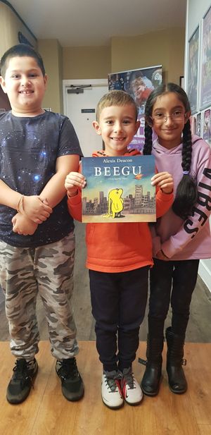 Alex Summan (8), Peter Zangov (7) and Komalpreet Kaur (7) from Merridale Primary School pose with one of Alexis' books