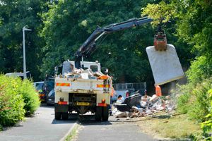 Workers clear up the the pile of rubbish 