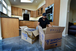 Mr Uppal unpacks in the new kitchen of his home in Penn