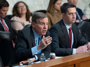 Mark Warner, left, joined at right by Chairman Tom Cotton, questioning Tulsi Gabbard who is off camera