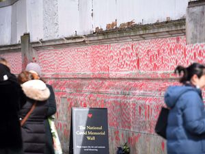 A view of the Covid Memorial Wall in London, with people alongside it