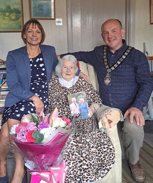 County Cllr Angela Davies, Mrs Lewis proudly showing her card from the King and Queen and her bouquet of flowers, and Rhayader Mayor Councillor Christian Walton