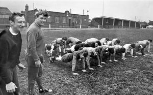 Walsall Wood Football Club in training, August 13, 1970: 'Fitness looks like being the keynote for Walsall Wood in the Midland Combination's first division, under the guidance of new manager Derek 'Doc' Pace, the former Aston Villa and Sheffield United centre forward. The players are put through press-ups watched by Pace (left) and trainer Albert Tomkinson.'