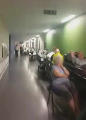Patients wait on beds stretched along the corridor at Stoke