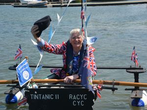 Michael Stanley waves his cap as he sits in his boat Tintanic