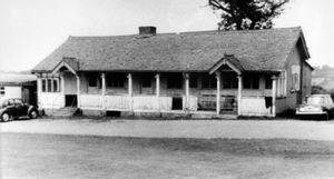 'Market Drayton Golf Club house, circa 1960.' This is hanging in the clubhouse at Market Drayton Golf Club and was copied in January 2017 with the permission of Denis Roberts, an honorary life member of the club. The car on the right is a Triumph Herald which first appeared in 1959. This particular clubhouse was known as the 'Polo Hut' as it was an old polo hut erected at the golf club. It did not stand on the same site as the modern clubhouse, sounds like it was about 200 yards or so away. This picture also appears in a book about the history of the club in which it is captioned: 'The second clubhouse was assembled in 1949 and was originally the Polo Pavilion at Budworth, near Delamere, Cheshire.'