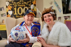 LAST COPYRIGHT SHROPSHIRE STAR STEVE LEATH 17/05/2022..Pic in Wellington at Priory Nursing Home, where Lawrence Jones was celebrating his 100th birthday. He is pictured and on some along with singer: Kerry Young, who was singing at his party. There are copy pics of Lawrence as a young man (1945), Lawrence with his wife: Eileen who passed last year aged 99. Also a copy pic from there wedding at Madeley Church. He is a big Shrewsbury Town fan and was sent a signed ball, and also a video message saying happy birthday from player: Daniel Udoh (Theres a screen grab from that too)..