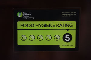 A Food Standards Agency rating sticker on a window of a restaurant. 