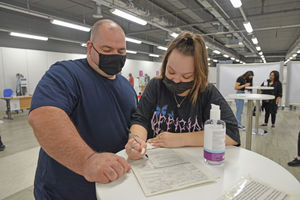 Katie Bonass gets her jab with the support of her dad James