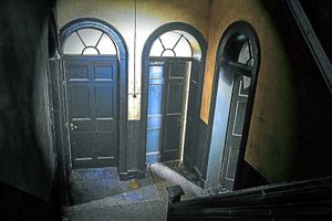 The hallway doors hiding rooms frozen in time since the house  was abandoned