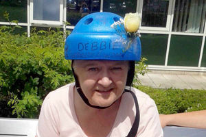 Wearing a padded helmet to protect her fragile skull