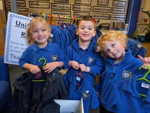 4-year-old Isla Bowen and 3-year-olds George Lewis and Reuben Evans with some of the many items of uniform for sale at Little Trinity Nursery.