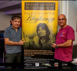Nash Aujla and Gurcharan Khanpur standing
next to banner from 1st Tribute concert for Dalbir Khanpur held at Tower Ballroom, 13 years.