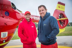 Crew modelling the charity branded red cap and blue hoodie.