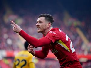 Liverpool’s Andy Robertson points with his left hand