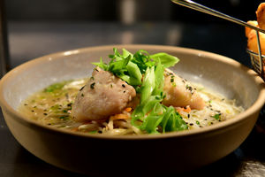 Oriental Sesame Hake, served with a spring onion dashi broth and vegetable noodles