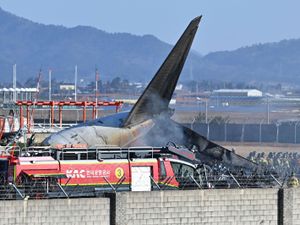 Firefighters and rescue team members work on the runway of Muan International Airport