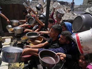 Palestinians struggle to get donated food at a community kitchen