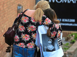 A fan is comforted as she leaves the Park Inn hotel in central Manchester
