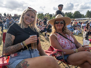 Two friends enjoying a drink in the sunshine before the music