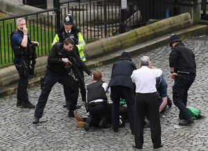 An armed policeman points a gun at a man on the floor while standing on what appears to be a knife