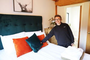 Brodie making a bed inside one of the lodges.