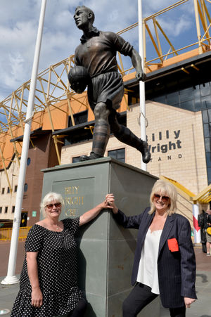 Sister Babette Woodham and Vicky Wright pose with their father's statue outside Molineux