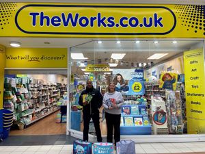 One Stop head of security Musa Sharif (L) handing over donated books to Canterbury Cross Schools business manager Alison King-Harmes (R) 