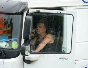 An Italian truck driver makes a phone call after being stopped by police