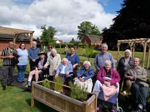 Residents and their families celebrate the opening of the sensory garden at Chirk Court Nursing Home. 