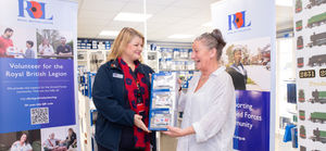Claire Lewis, the Poppy Appeal Manager for North Wales, with Dapol's factory manager, Samantha Jones, and some of the commemorative wagons.
