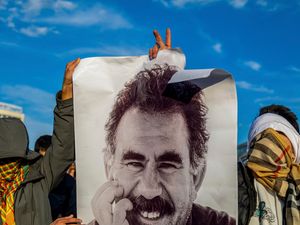 Young people hold a photograph of the jailed leader of the rebel Kurdistan Workers’ Party, or PKK, Abdullah Ocalan