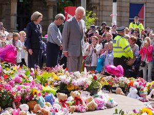 King Charles looking at wreaths in Southport