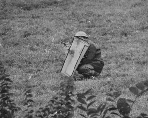 Superintendent Bob Landers approaches the property with a revolver and riot shield