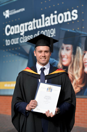 Kristian Thomas celebrates after receiving his degree
