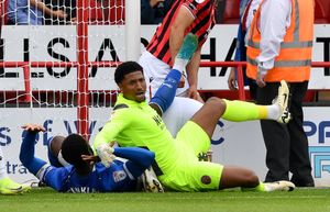 Walsall goalkeeper Myles Roberts battles for the ball inside the box.